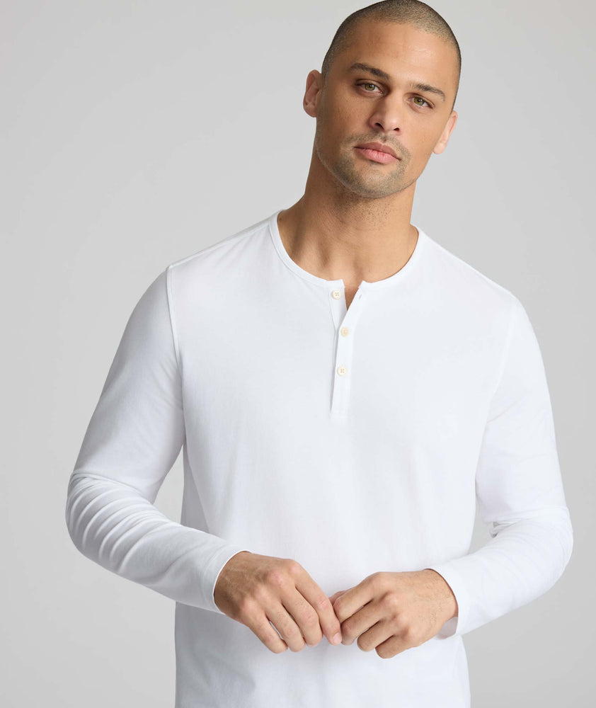 Model wearing a white long-sleeve henley.