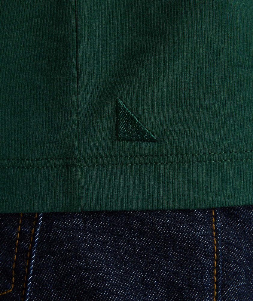 Model wearing a green long-sleeve henley.