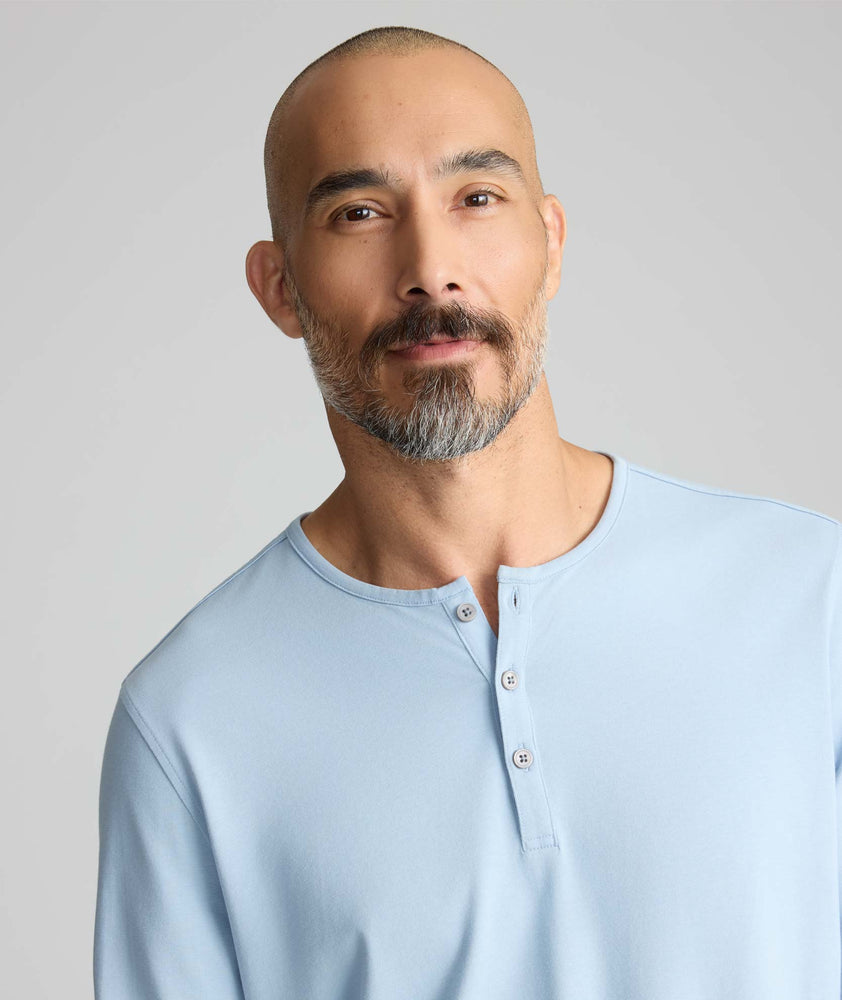 Model wearing a light blue long-sleeve henley.