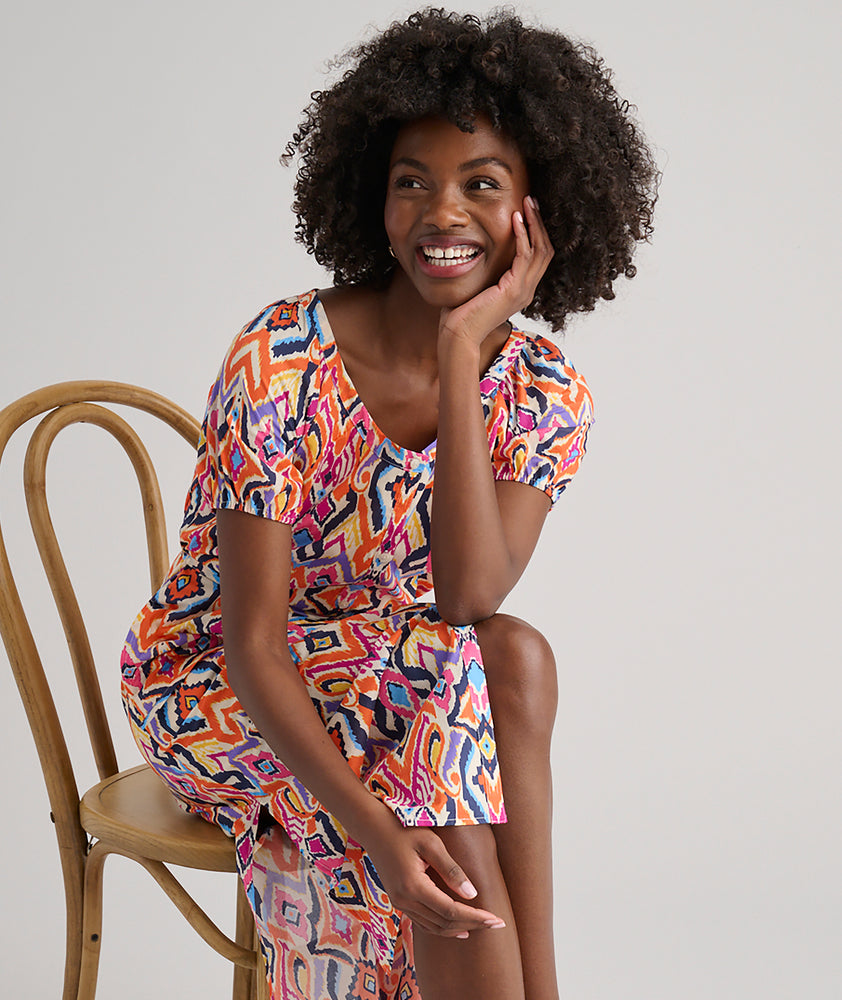 Model is wearing UNTUCKit Marguerite printed orange dress. 