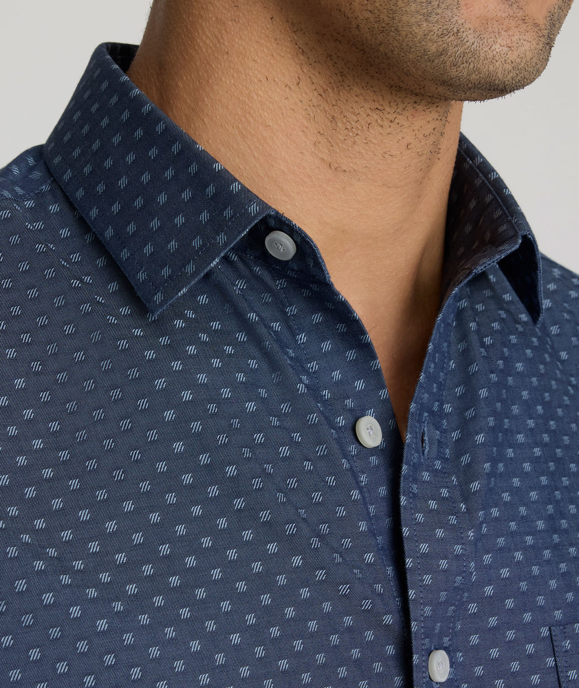 Model is wearing UNTUCKit Mcbride Wrinkle-free shirt in printed chambray. 