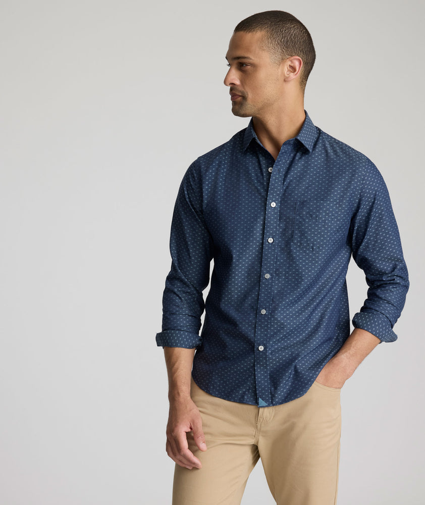 Model is wearing UNTUCKit Mcbride Wrinkle-free shirt in printed chambray. 
