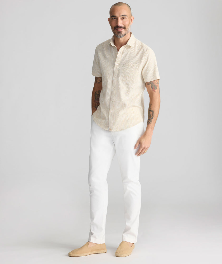 Model is wearing UNTUCKit Stretch Cotton Hybrid Pant in Cream. 