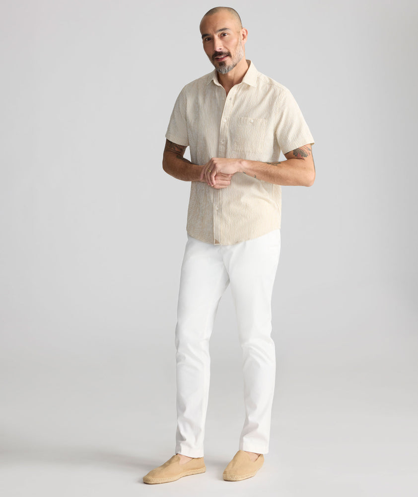 Model is wearing UNTUCKit Stretch Cotton Hybrid Pant in Cream. 