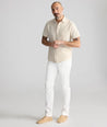 Model is wearing UNTUCKit Stretch Cotton Hybrid Pant in Cream. 