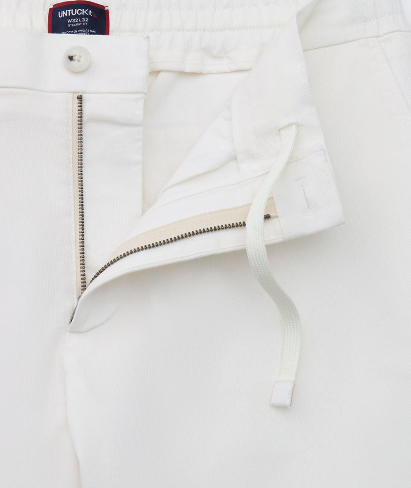 Model is wearing UNTUCKit Stretch Cotton Hybrid Pant in Cream. 