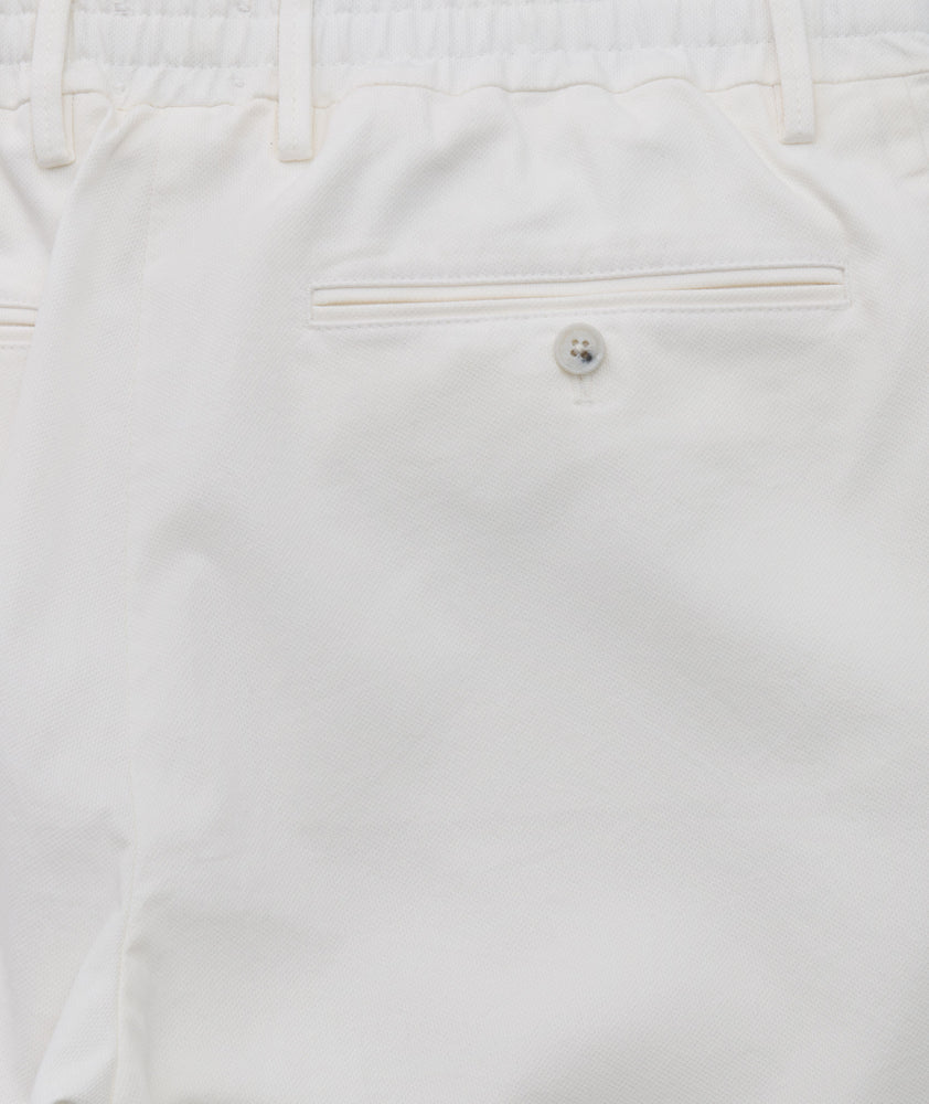 Model is wearing UNTUCKit Stretch Cotton Hybrid Pant in Cream. 