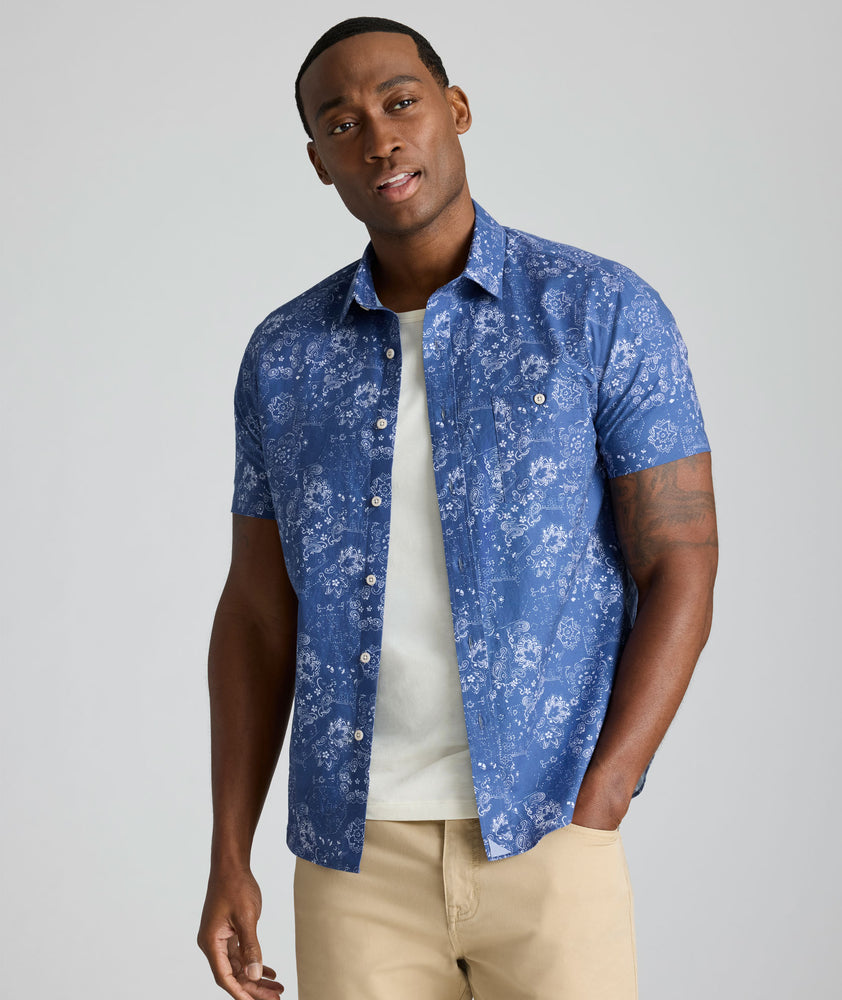 Model is wearing UNTUCKit Monroe cotton linen short sleeve shirt in blue print. 
