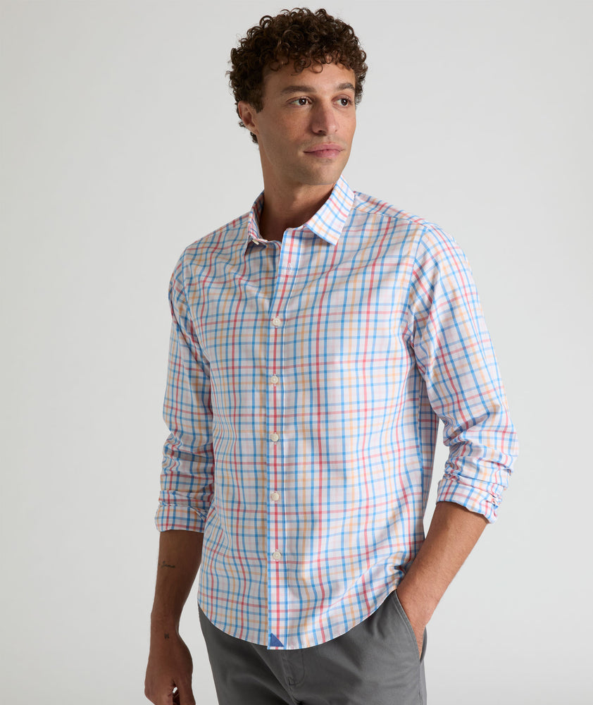 Model is wearing UNTUCKit Moore shirt in blue, orange and pink check.
