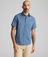 Model is wearing UNTUCKit Vintage Wash Short-Sleeve Normand Shirt in navy. 
