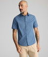 Model is wearing UNTUCKit Vintage Wash Short-Sleeve Normand Shirt in navy. 