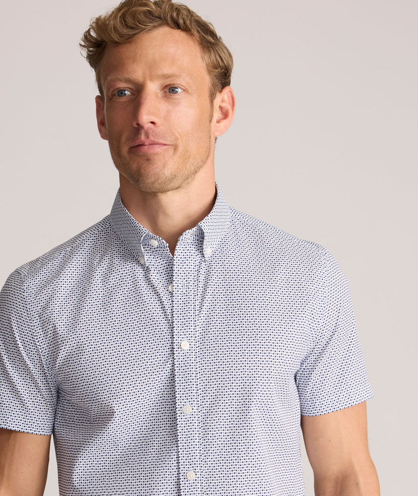 Model is wearing UNTUCKit Performance Short-Sleeve Nouveau Shirt in Navy Geo Print.