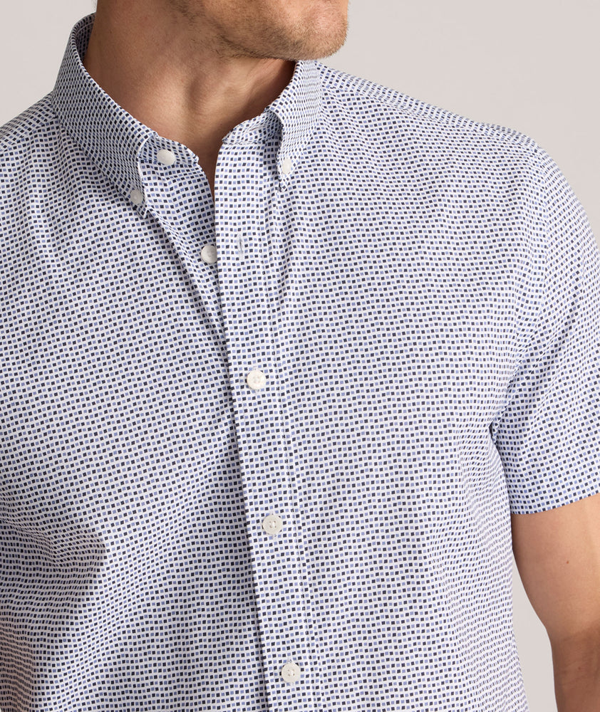 Model is wearing UNTUCKit Performance Short-Sleeve Nouveau Shirt in Navy Geo Print.
