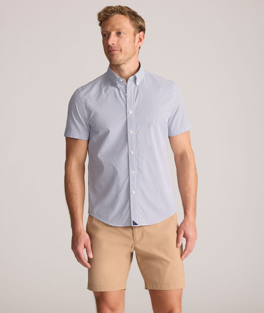 Model is wearing UNTUCKit Performance Short-Sleeve Nouveau Shirt in Navy Geo Print.