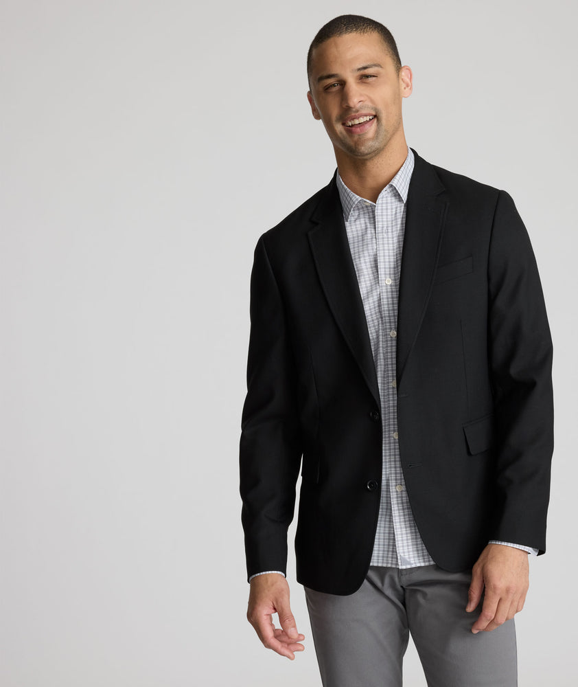 Model is wearing UNTUCKit Palazzo sport coat in black.