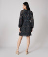 Model is wearing UNTUCKit Paloma dress in black print.