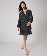 Model is wearing UNTUCKit Paloma dress in black print. 