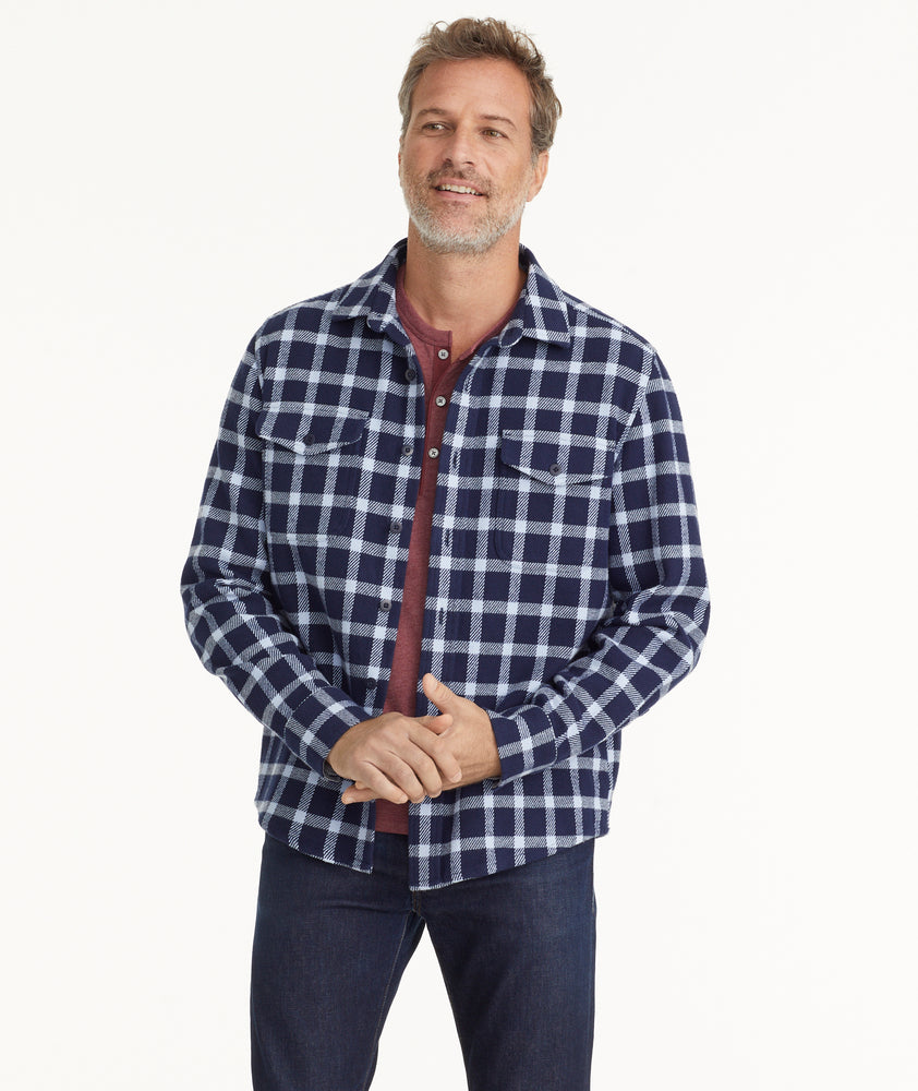 Model is wearing UNTUCKit Brushed Overshirt in Navy & Light Blue Check.