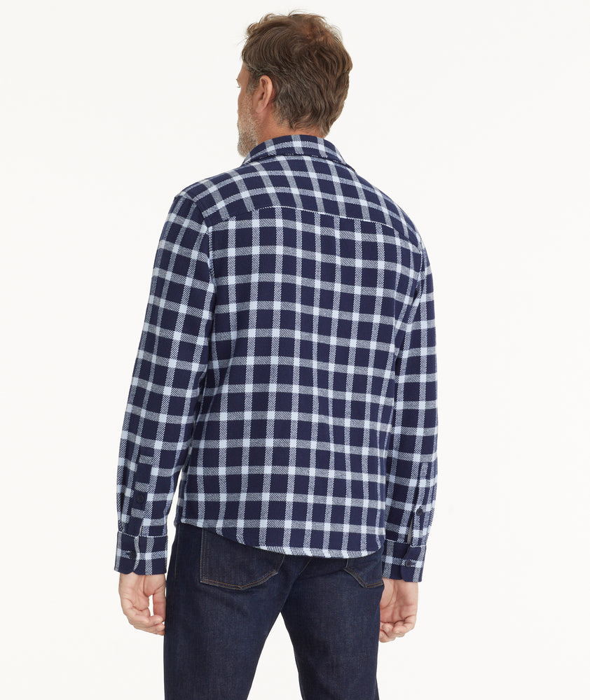 Model is wearing UNTUCKit Brushed Overshirt in Navy & Light Blue Check.