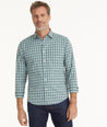 Model is wearing UNTUCKit Wrinkle-Free Performance Prescott Shirt in Sage Green Check.