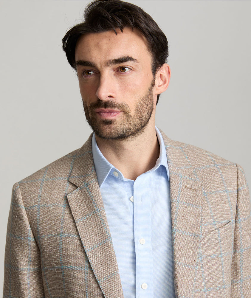 Model is wearing UNTUCKit price sport coat in tan. 