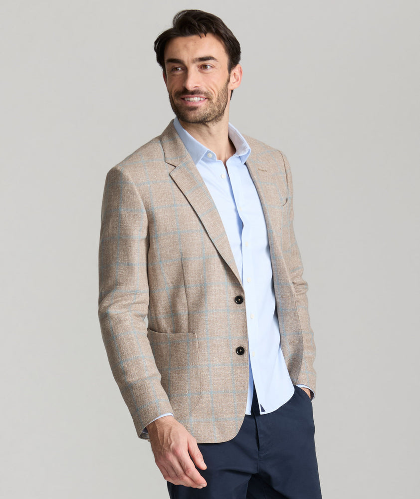 Model is wearing UNTUCKit price sport coat in tan. 