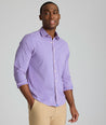 Model is wearing UNUCKit Quinby performance gingham button-down in pink. 