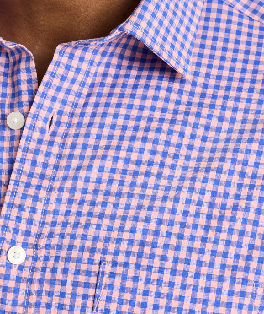 Model is wearing UNUCKit Quinby performance gingham button-down in pink. 