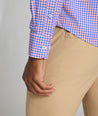 Model is wearing UNUCKit Quinby performance gingham button-down in pink. 
