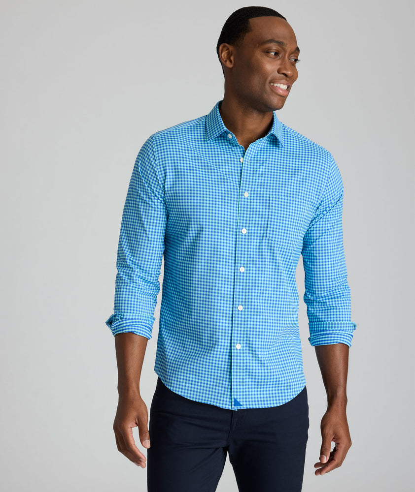 Model is wearing UNTUCKit Quinby performance gingham shirt in blue. 