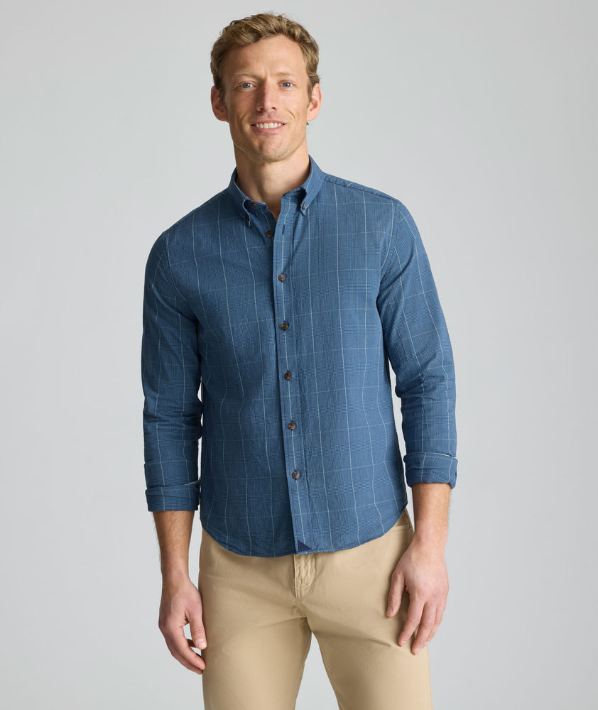 Model is wearing UNTUCKit Vintage Wash Quinnell Shirt in navy. 