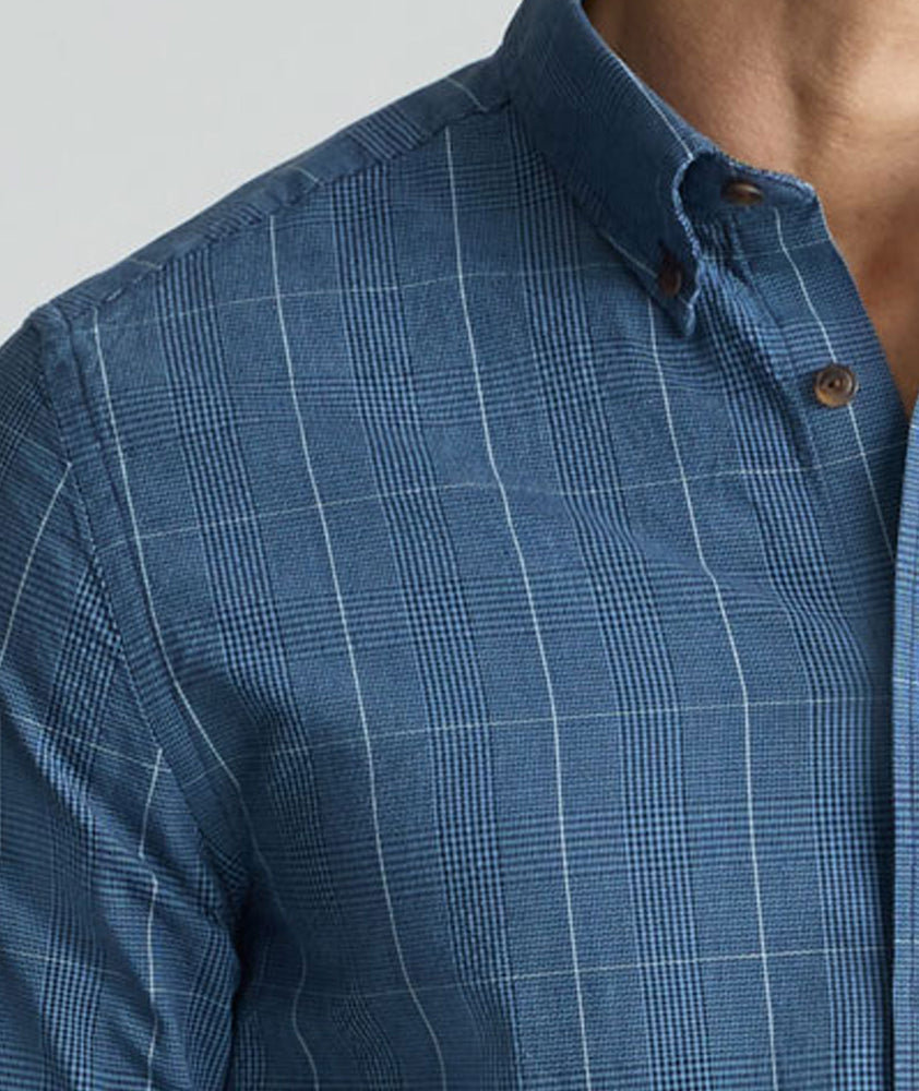 Model is wearing UNTUCKit Vintage Wash Quinnell Shirt in navy. 