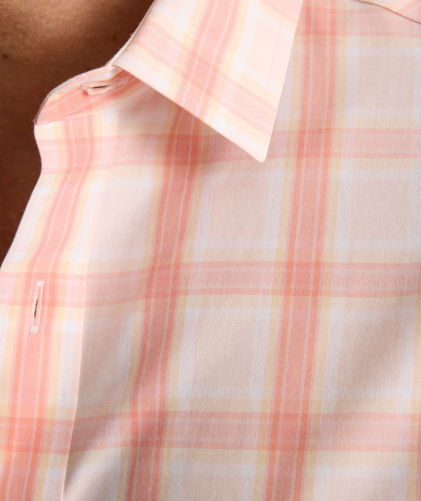 Model is wearing UNTUCKit ravenswood wrinkle free plaid plaid shirt in orange. 