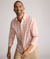 Model is wearing UNTUCKit ravenswood wrinkle free plaid plaid shirt in orange. 