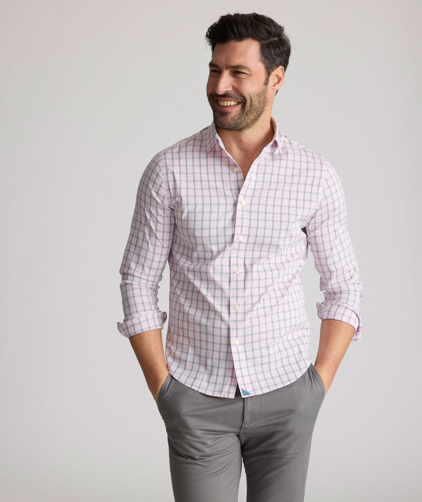 Model is wearing UNTUCKit Raynard cottentek shirt in pink windowpane. 