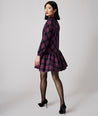 Model is wearing UNTUCKit Reese dress in purple plaid.