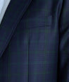Model is wearing UNTUCKit Italian Wool Reims Sport Coat in Navy With Green Windowpane.