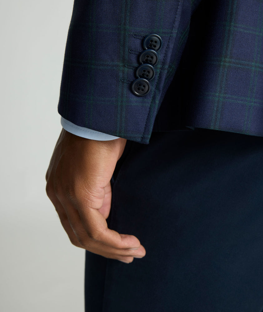 Model is wearing UNTUCKit Italian Wool Reims Sport Coat in Navy With Green Windowpane.