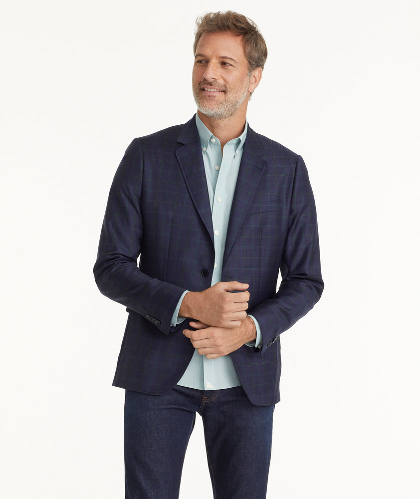 Model is wearing UNTUCKit Italian Wool Reims Sport Coat in Navy With Green Windowpane.