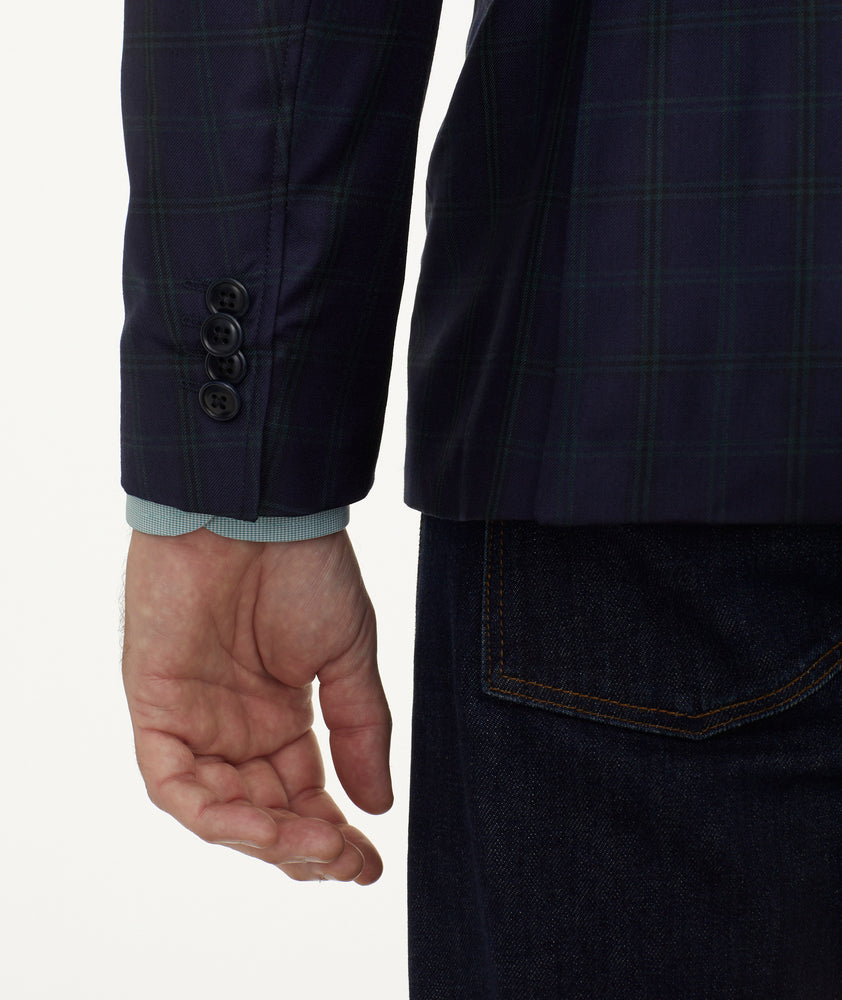Model is wearing UNTUCKit Italian Wool Reims Sport Coat in Navy With Green Windowpane.