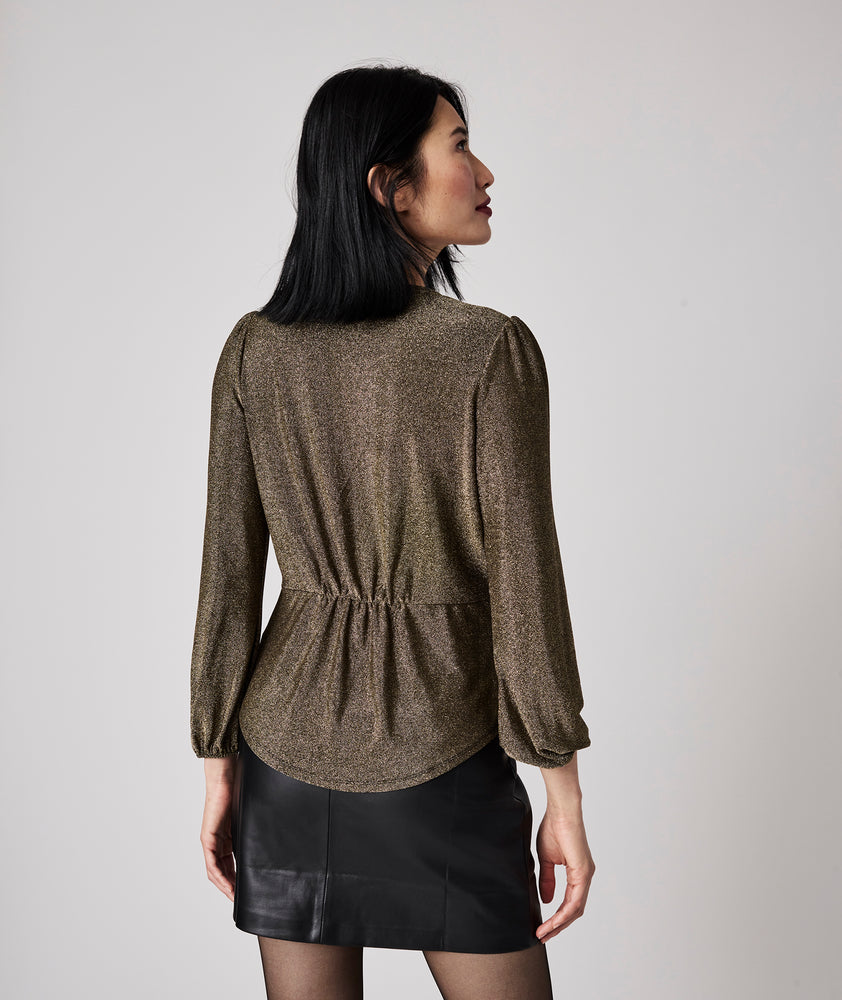 Model is wearing UNTUCKit Scarlett gold top.