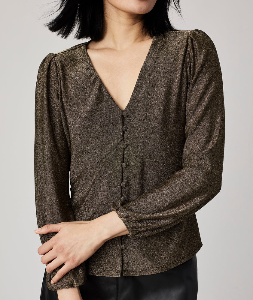 Model is wearing UNTUCKit Scarlett gold top.