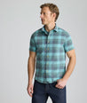 Model is wearing UNTUCKit Vintage Wash Short-Sleeve Silverstone Shirt in blue. 