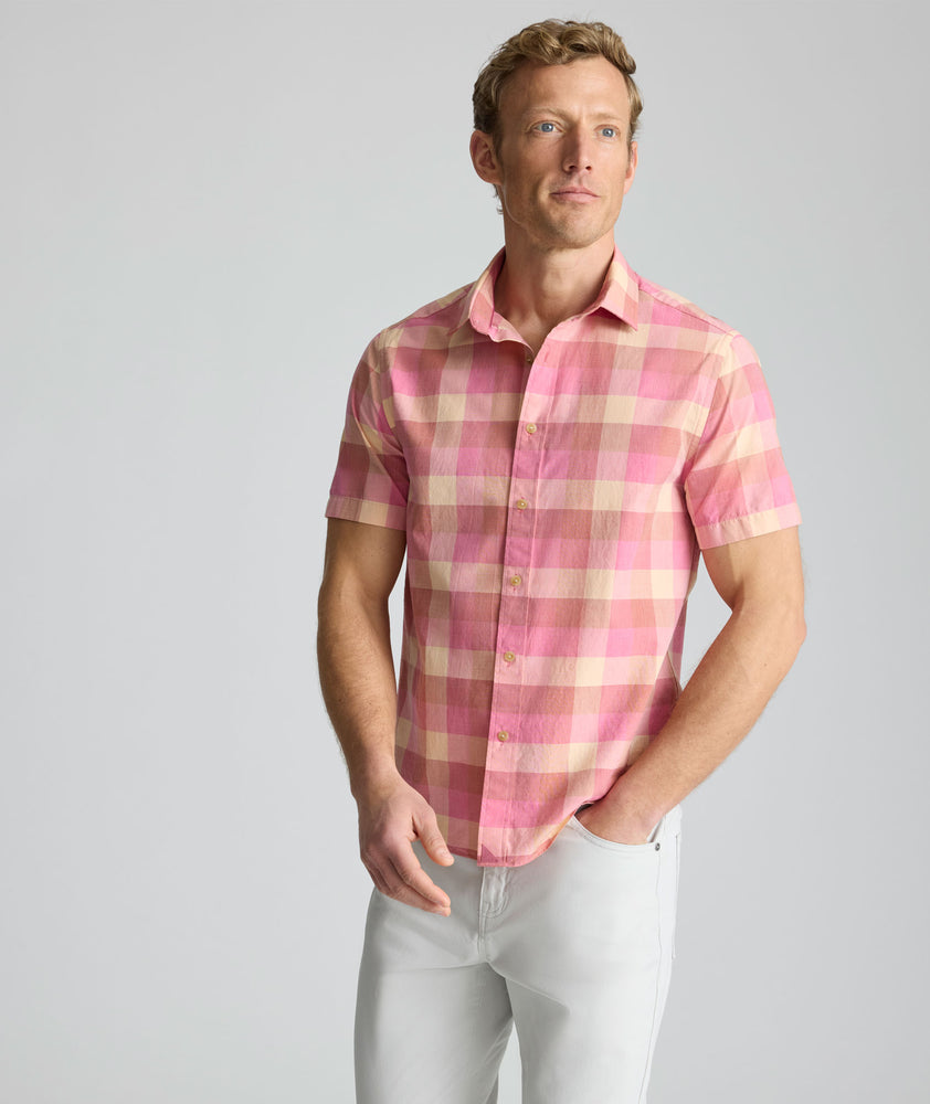 Model is wearing UNTUCKit Vintage Wash Short-Sleeve Silverstone Shirt in pink. 