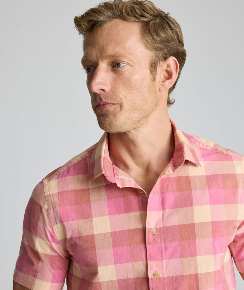 Model is wearing UNTUCKit Vintage Wash Short-Sleeve Silverstone Shirt in pink. 