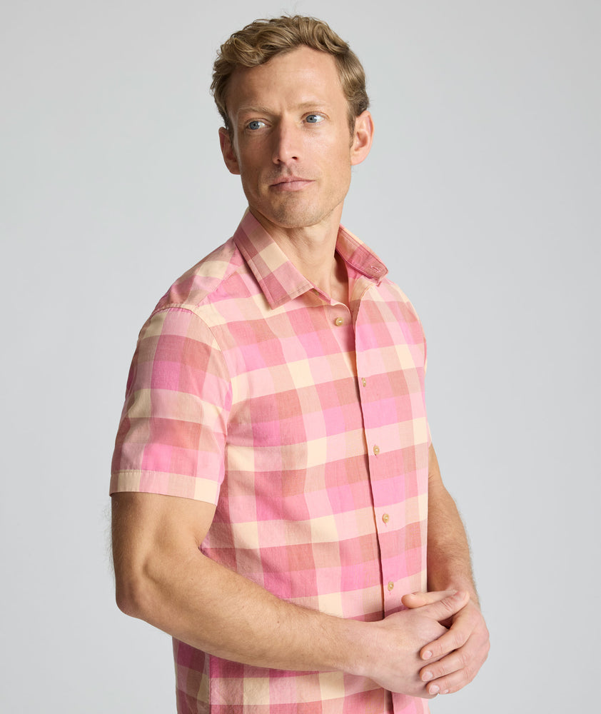 Model is wearing UNTUCKit Vintage Wash Short-Sleeve Silverstone Shirt in pink. 