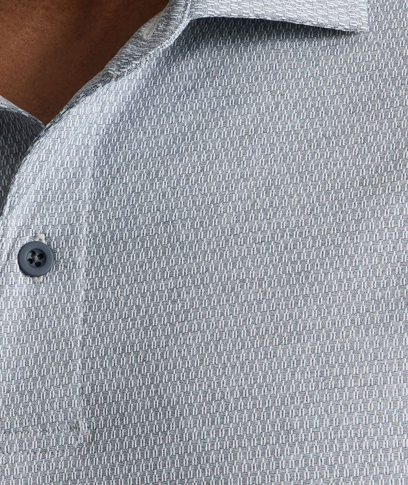 Model is wearing UNTUCKit Textured Performance Polo in navy. 