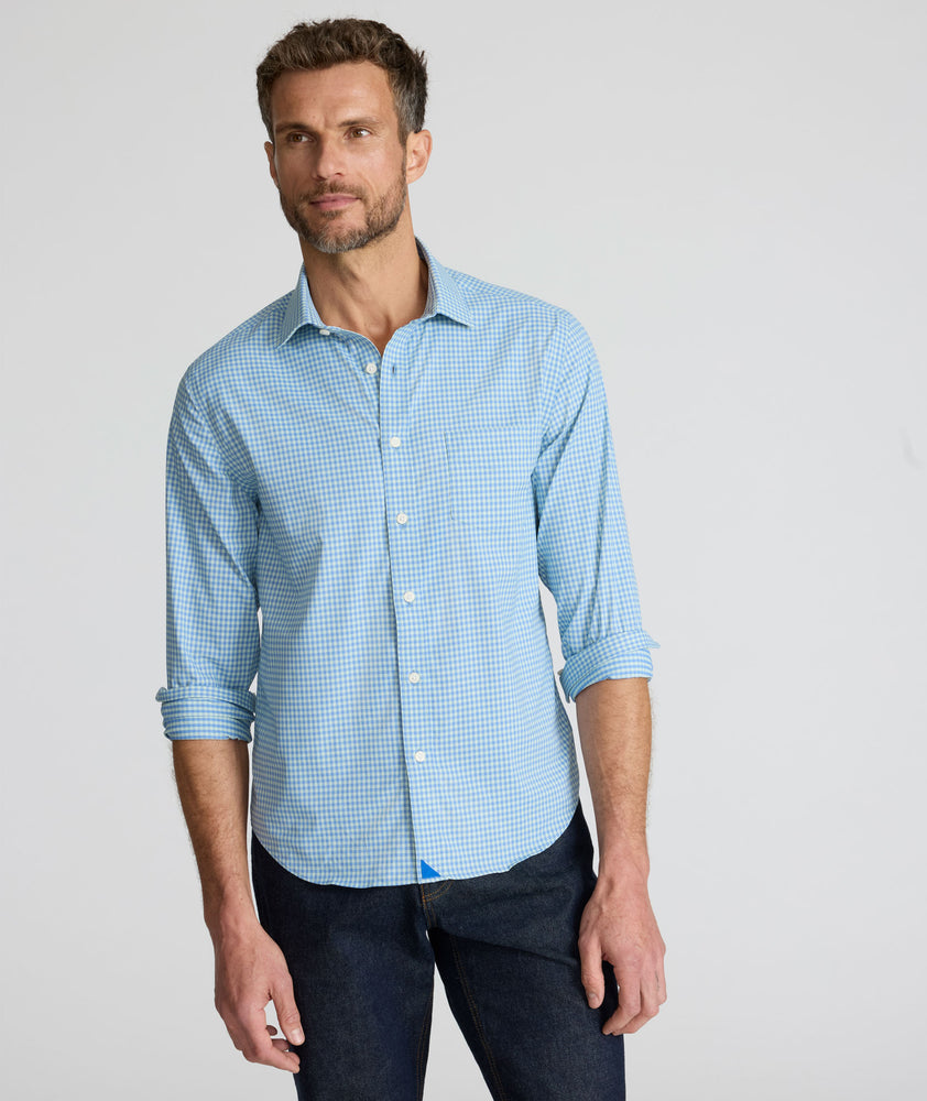Model is wearing UNTUCKit Starling performance shirt in blue green.