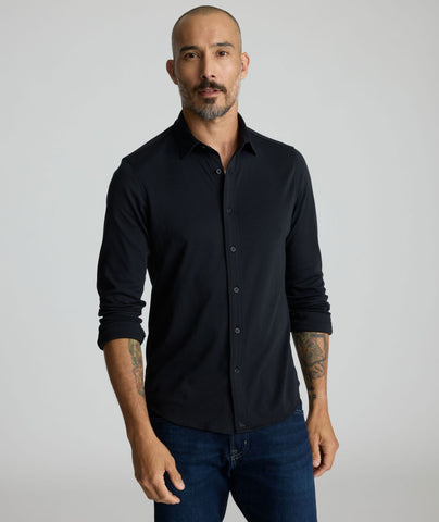 Model is wearing UNTUCKit Sullivan wrinkle-free knit in solid black. 