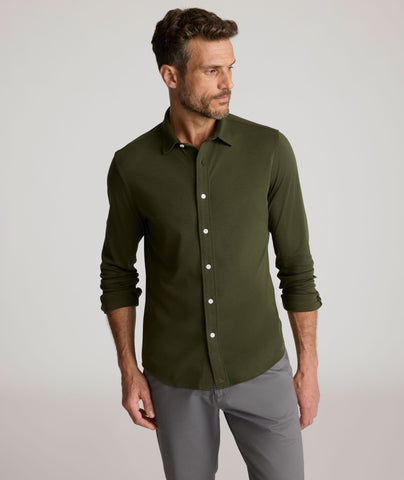 Model is wearing UNTUCKit Sullivan wrinkle-free knit shirt in forest green. 